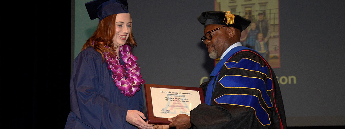 Public Health graduate receiving award from Dr. Ehiri at convocation